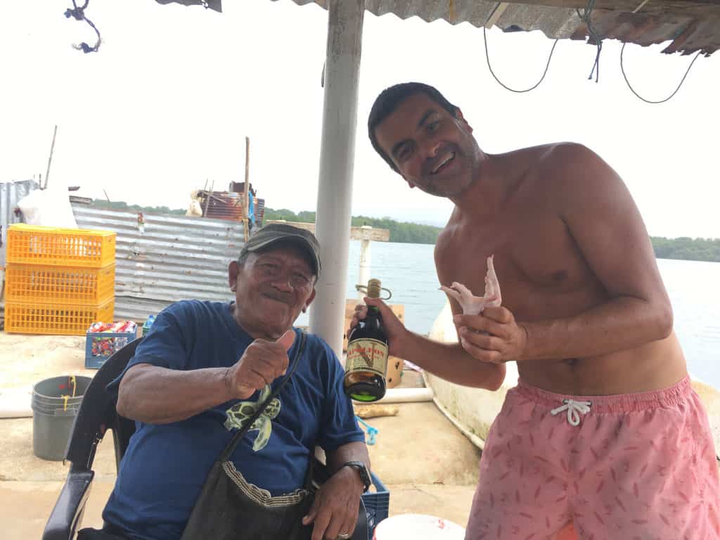 Regalando una botella de Cognac y dos patas de pollo a Federico de Narganá.