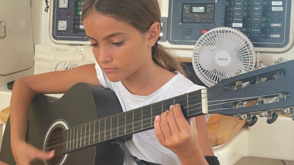 Mia aprendiendo a tocar la guitarra.